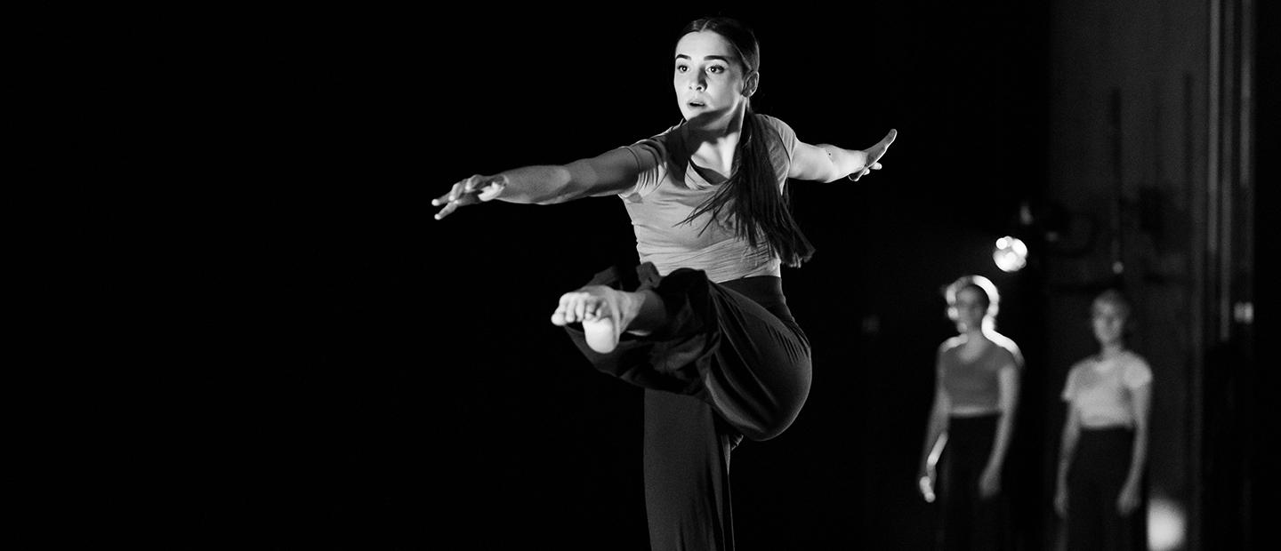 image of a solo female dancer onstage with her leg extended